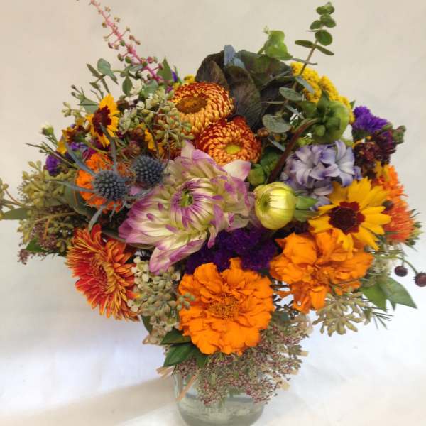 Mixed bouquet of bright flowers in a clear glass vase