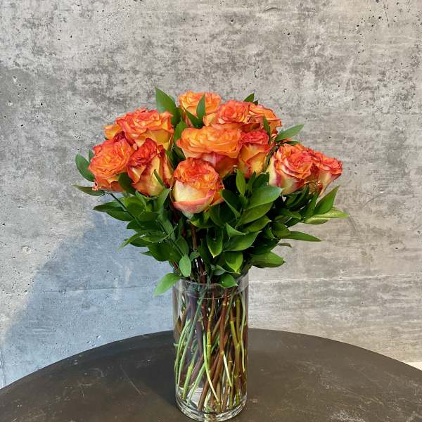 Orange roses in a clear glass vase