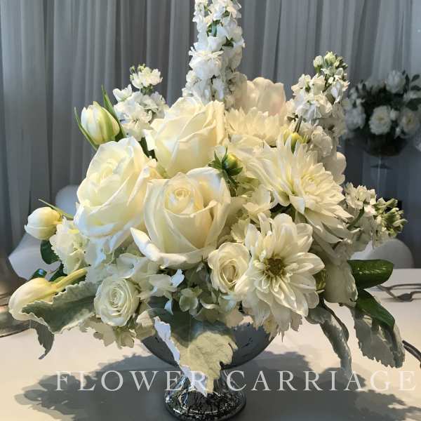 White floral centerpiece in a silver pedestal bowl