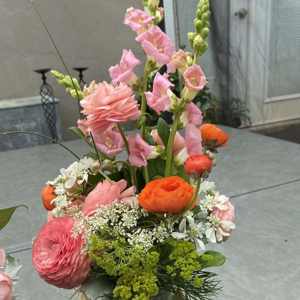 Mixed bouquet in a clear glass vase with pink and orange blooms
