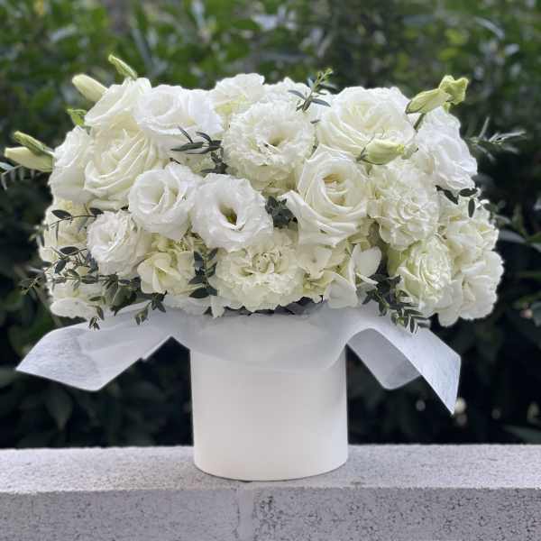 White rose and carnation bouquet in a white hatbox