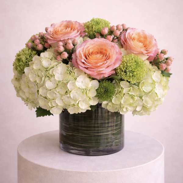 Pink roses and white hydrangeas in a dark glass vase
