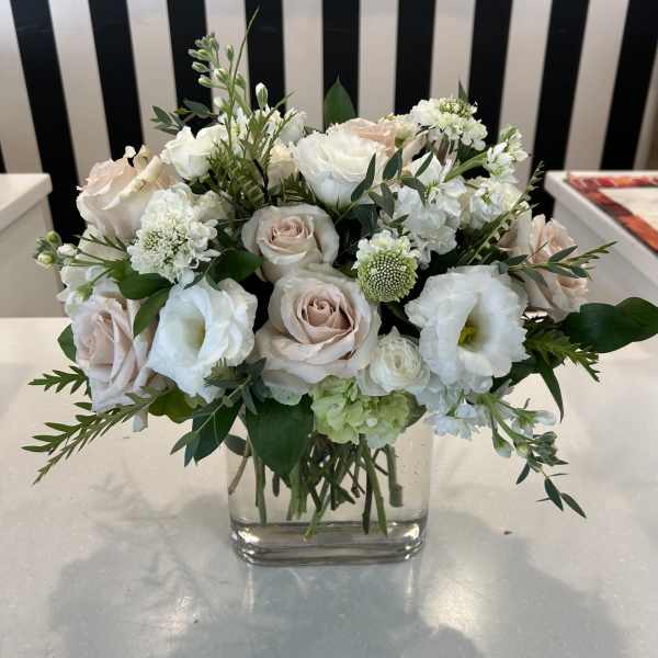 White and blush bouquet in a clear square vase