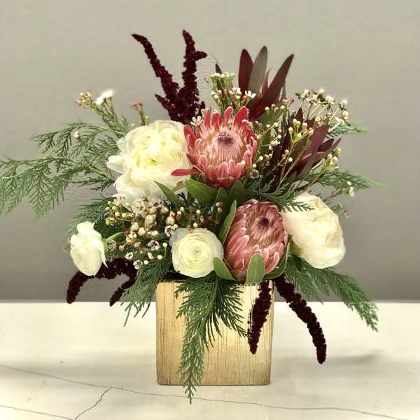 Mixed bouquet in a gold square vase with pink and white blooms