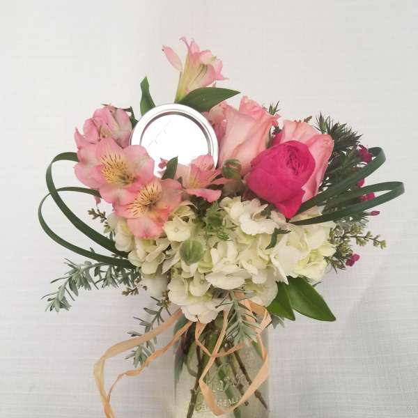 Pink and white flower arrangement in a mason jar vase
