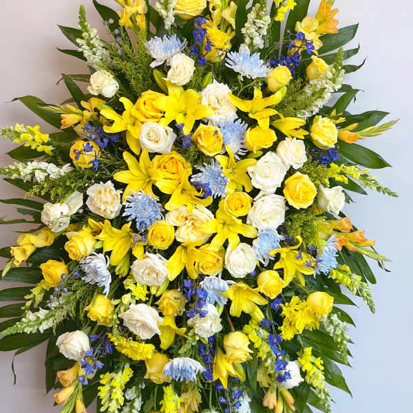 Large standing spray of yellow, white, and blue flowers