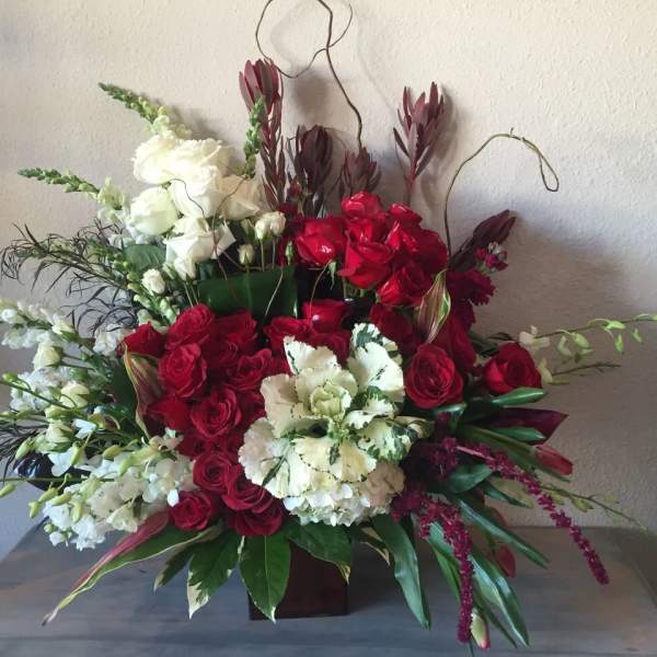 Red and white floral arrangement in a low container