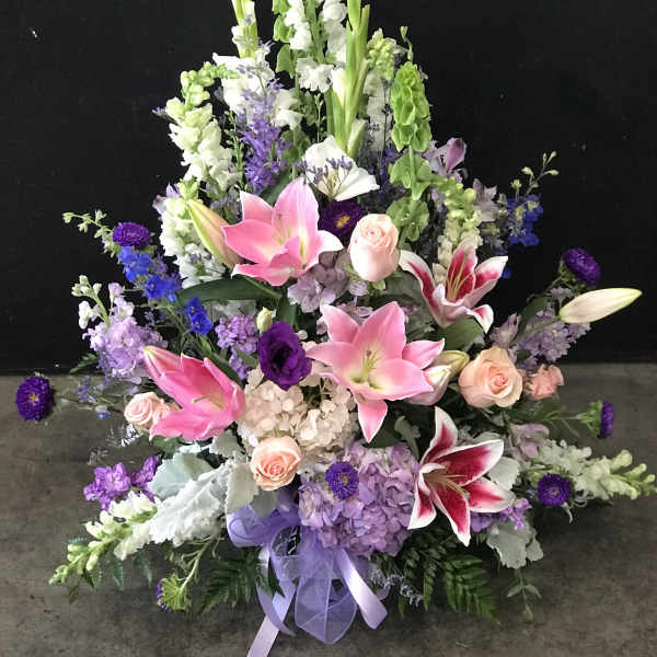Large floral spray with pink lilies, roses, and purple flowers