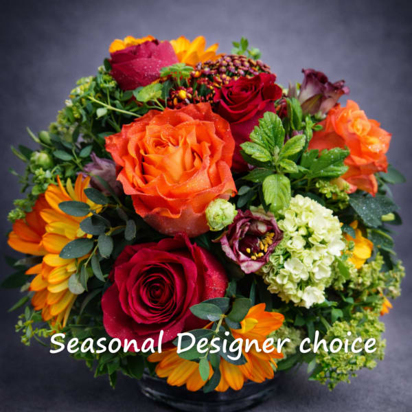 Mixed bouquet of red, orange, and yellow flowers in a vase