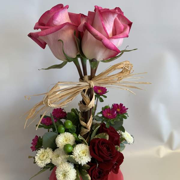 Pink roses in a vase with red and white flowers