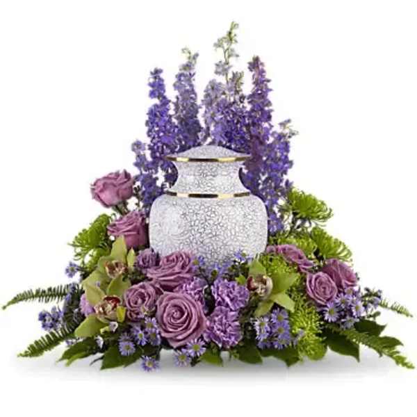 Purple roses and tall purple flowers arranged around a white urn