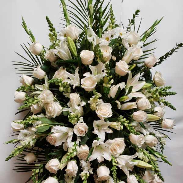 Large white floral standing spray with roses and lilies