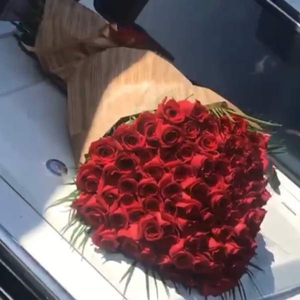 Large bouquet of red roses wrapped in brown paper
