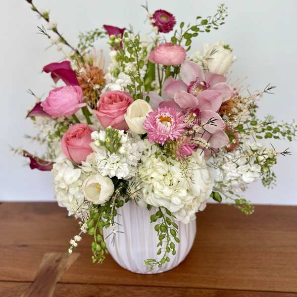Pink and white mixed flower arrangement in a white vase