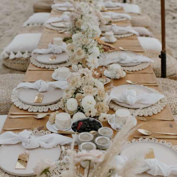 Long banquet table with white floral centerpieces and place settings