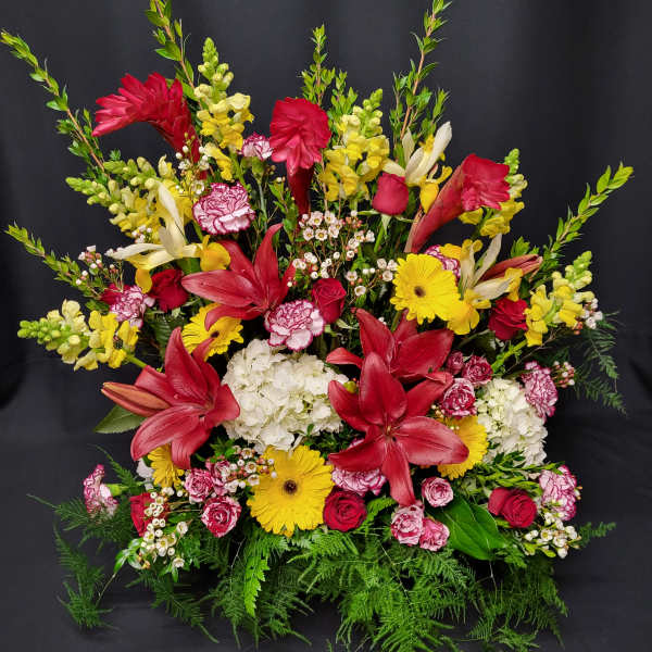 Large mixed bouquet with red lilies, yellow daisies, and pink roses