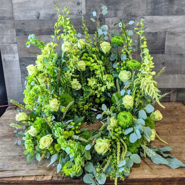 Large circular wreath of pale green roses and green blooms in a lush garden style.