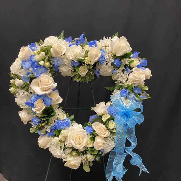 Heart-shaped floral wreath with cream roses, white blooms, and blue flowers