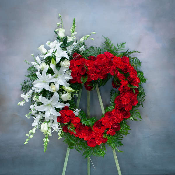 Two floral funeral wreaths, one red and one white, on easels