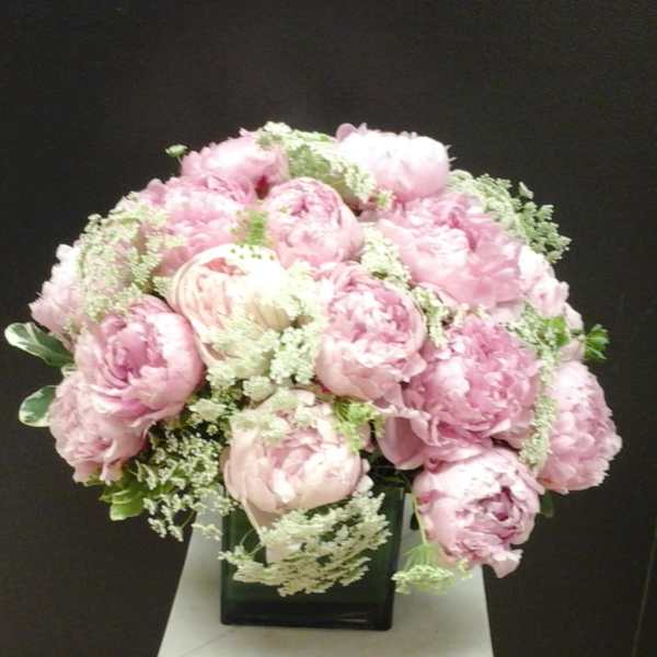 Pink peony bouquet in a square glass vase