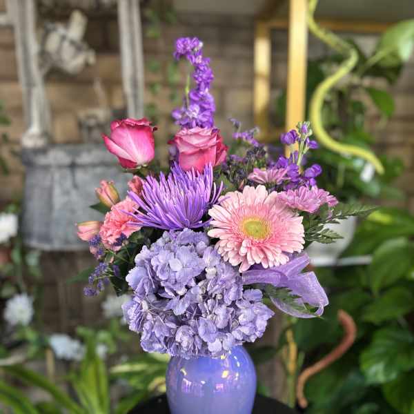 Purple and pink mixed bouquet in a lavender vase