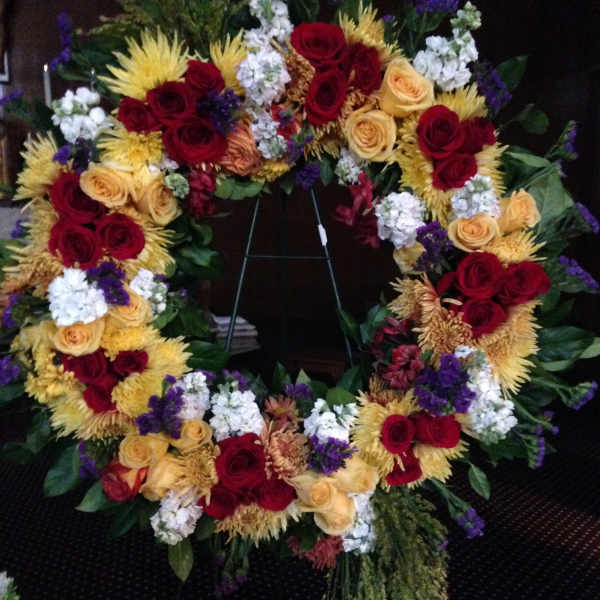 Large floral wreath with red and yellow roses and white accents