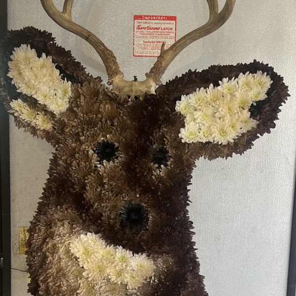 Deer head wall mount covered in white and dark flowers