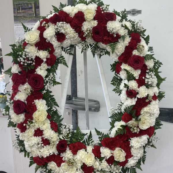 Large red and white floral wreath on a stand