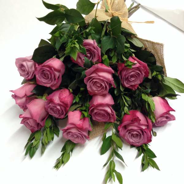 Bouquet of pink roses with greenery wrapped in burlap