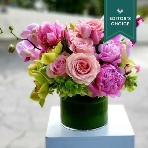 Pink and purple bouquet in a green glass vase