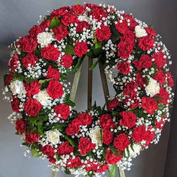 Red and white carnation wreath on a stand
