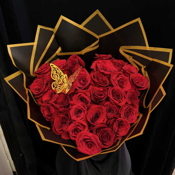 Heart-shaped bouquet of red roses with black and gold wrapping