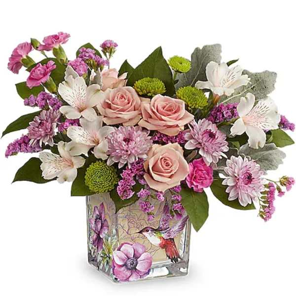 Pink roses and mixed blooms arranged in a decorative glass vase