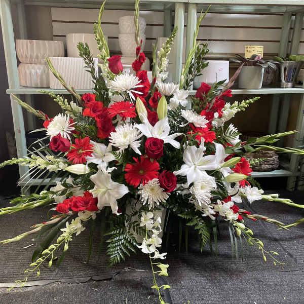 Large red and white floral spray with lilies, roses, and daisies