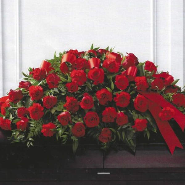 Large red rose casket spray with ribbon accents