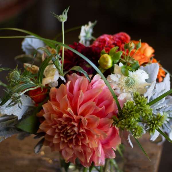 Mixed bouquet with a large pink dahlia in a glass vase