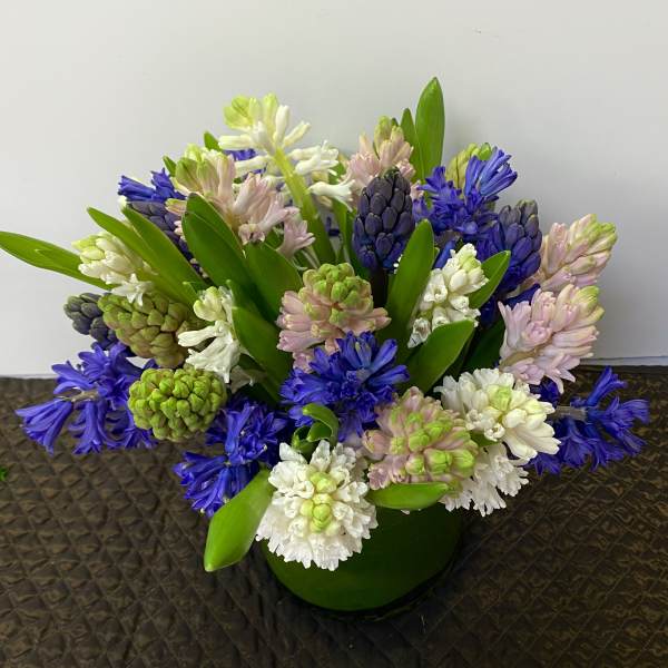 Bouquet of purple, white, and pink hyacinths in a green vase
