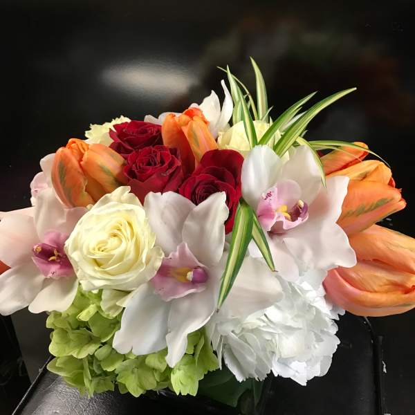 Bouquet of red and cream roses with white orchids and orange tulips
