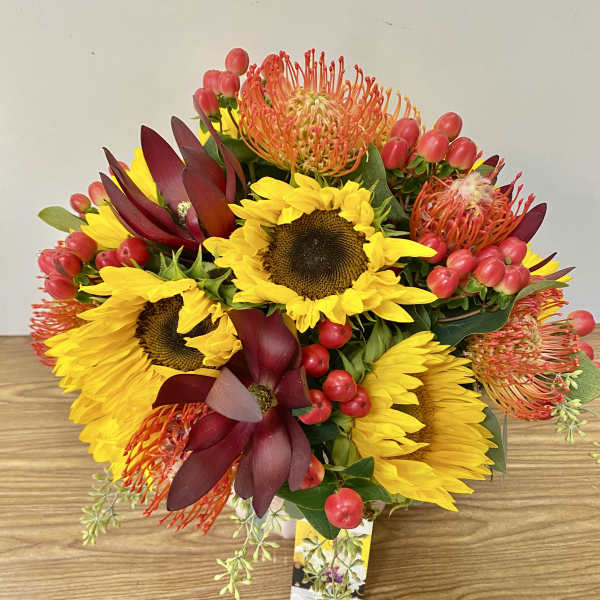 Bouquet of yellow sunflowers with burgundy and orange tropical blooms