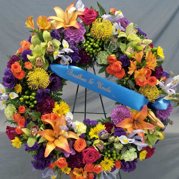 Colorful floral wreath with a blue ribbon reading Brother & Uncle
