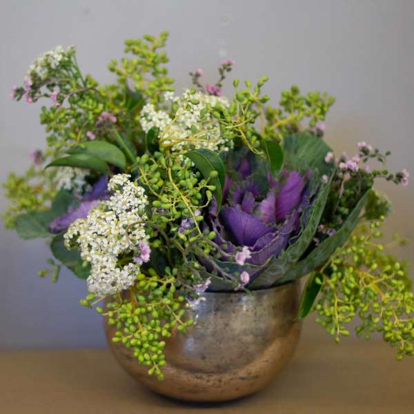 Purple and white floral arrangement in a metallic bowl vase