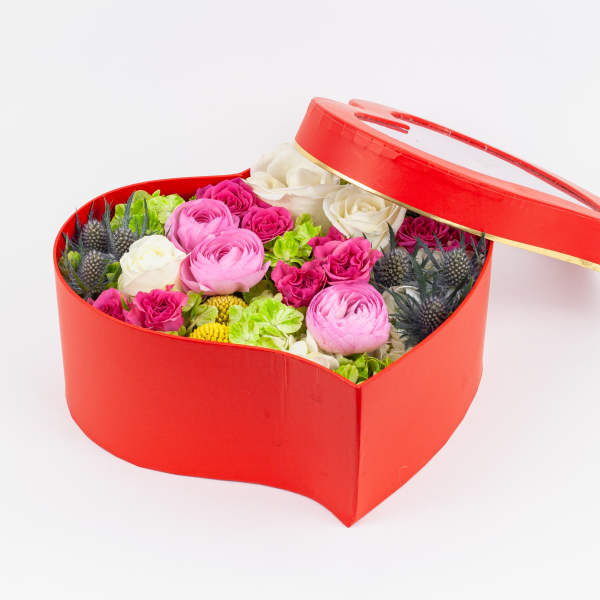 Heart-shaped red box filled with pink and white flowers
