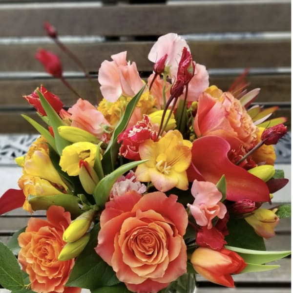 Bouquet of orange, pink, and yellow flowers in a glass vase
