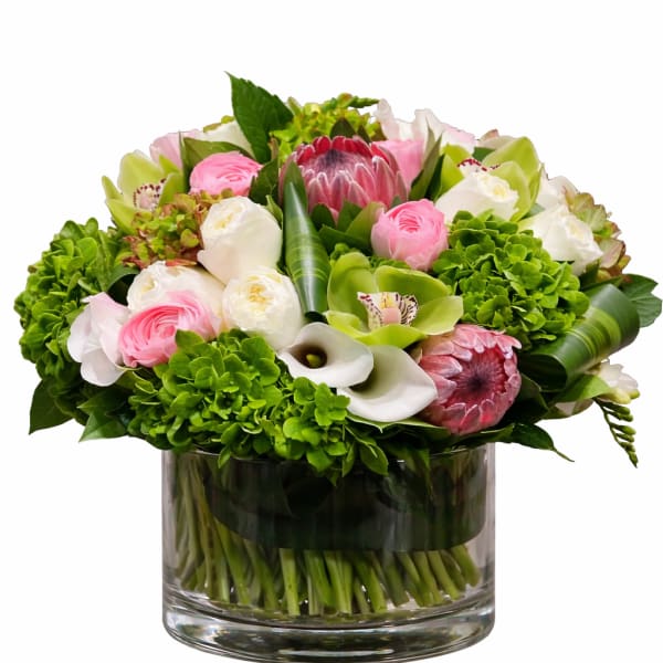 Pink and white flowers arranged in a clear glass vase