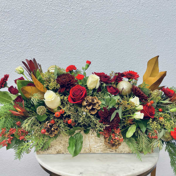 Long holiday centerpiece with red and white roses in a wooden box