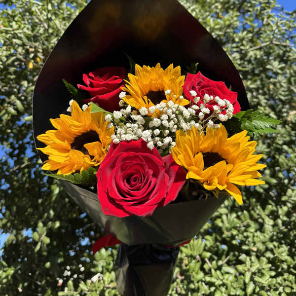 Bouquet of red roses and yellow sunflowers wrapped in black paper