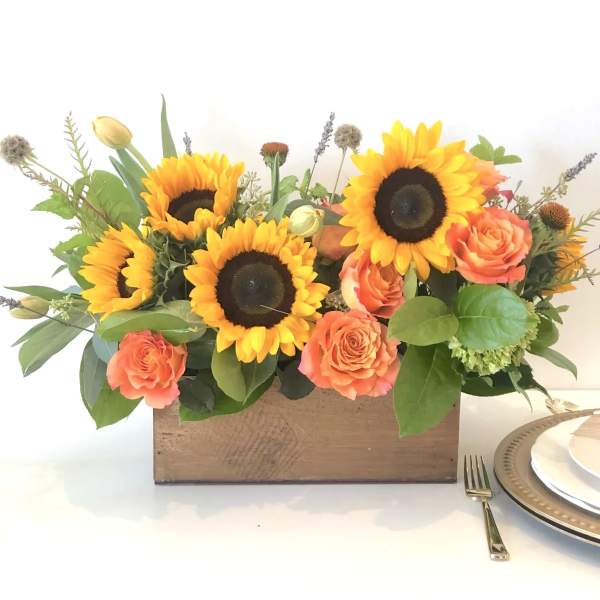 Sunflower and coral rose arrangement in a wooden box