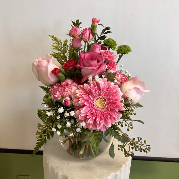 Pink roses and a gerbera daisy in a glass vase