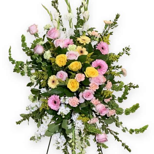 Standing floral spray with pink, yellow, and white flowers on an easel