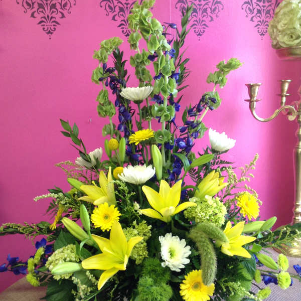 Tall mixed floral arrangement with yellow lilies and white daisies